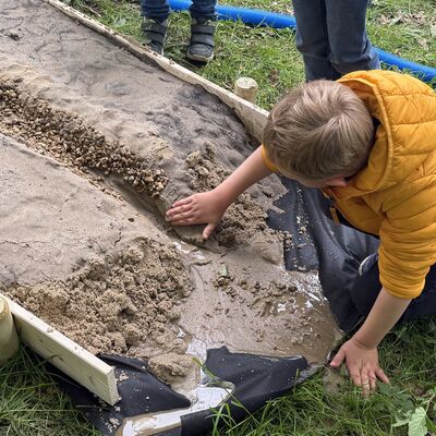An eigens bereitgestellten Modellen konnten die jungen Teilnehmerinnen und Teilnehmer spielerische Einblicke in die Gew&auml;sserplanung gewinnen. (Foto: Stadt Ibbenb&uuml;ren / Max Bertemes)
